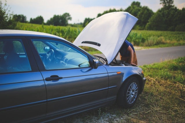 Person on side of road checking their engine