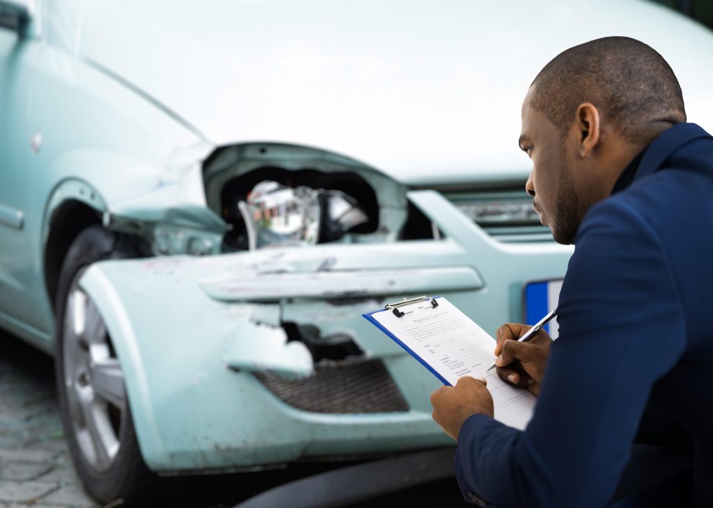 insurance appraiser checks car bumper damage