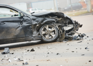 The front of a car is completely crushed after a severe accident, symbolizing the tragic outcome of a high-speed car crash.