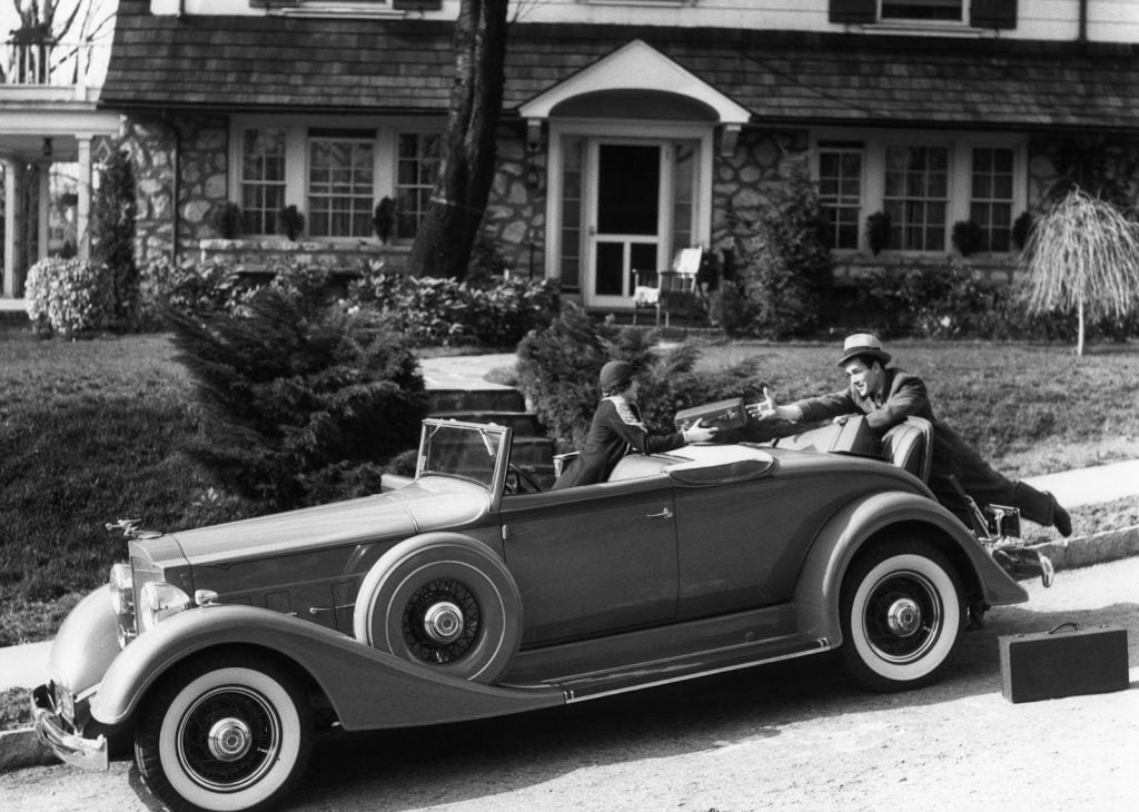 couple loading luggage in 1930s, American road trips