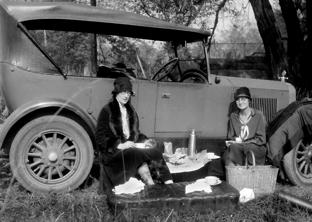 women at a picnic next to model a