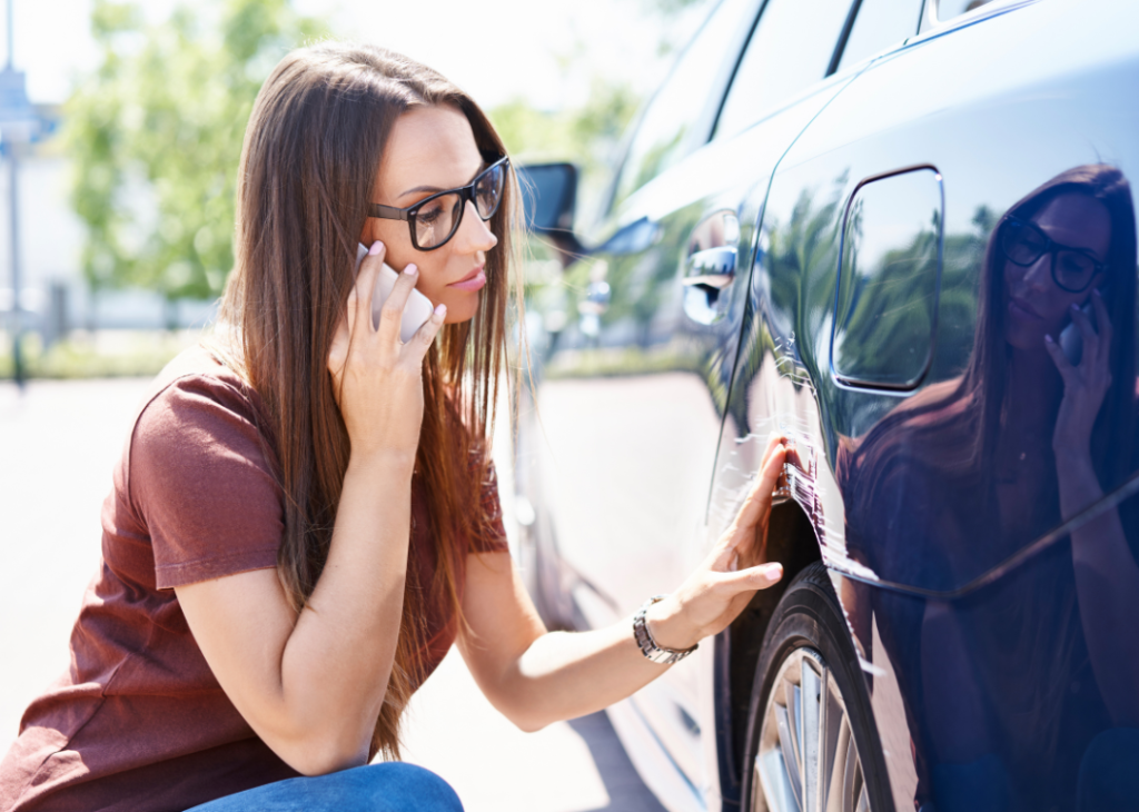 woman inspecting car damage