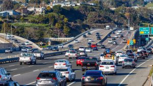 Heavy traffic on a multi-lane freeway, illustrating the challenge of lane changing and the perception of a faster commute.