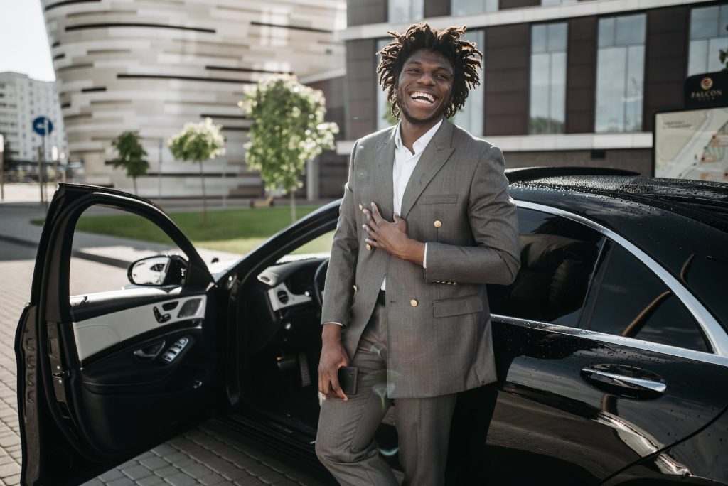 man standing outside of car smiling