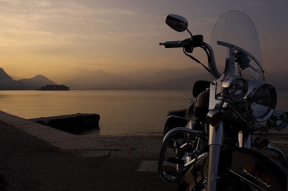 Motorcycle on kick stand near a lake.