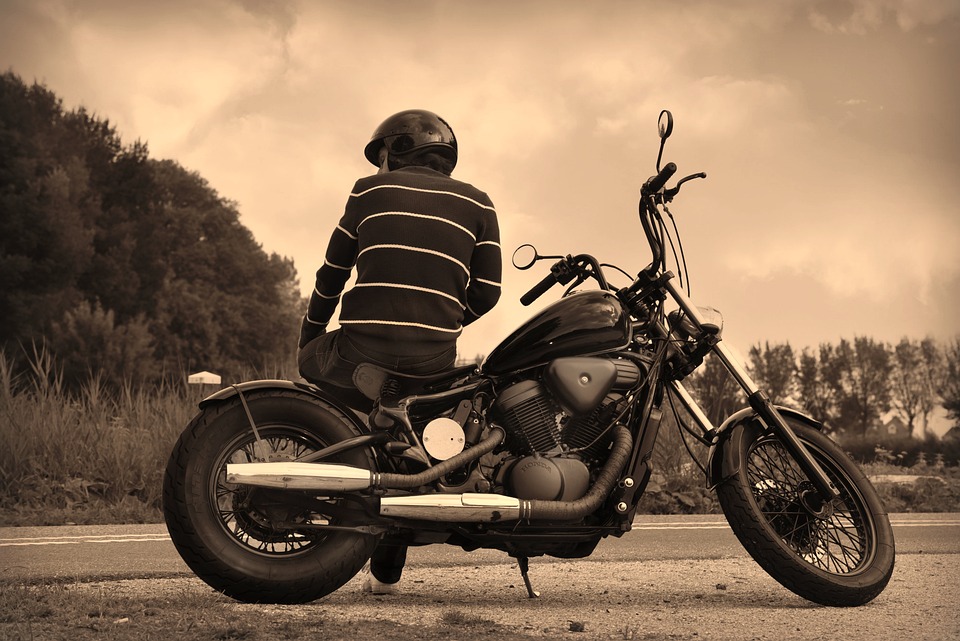 Man leaning on motorcycle.