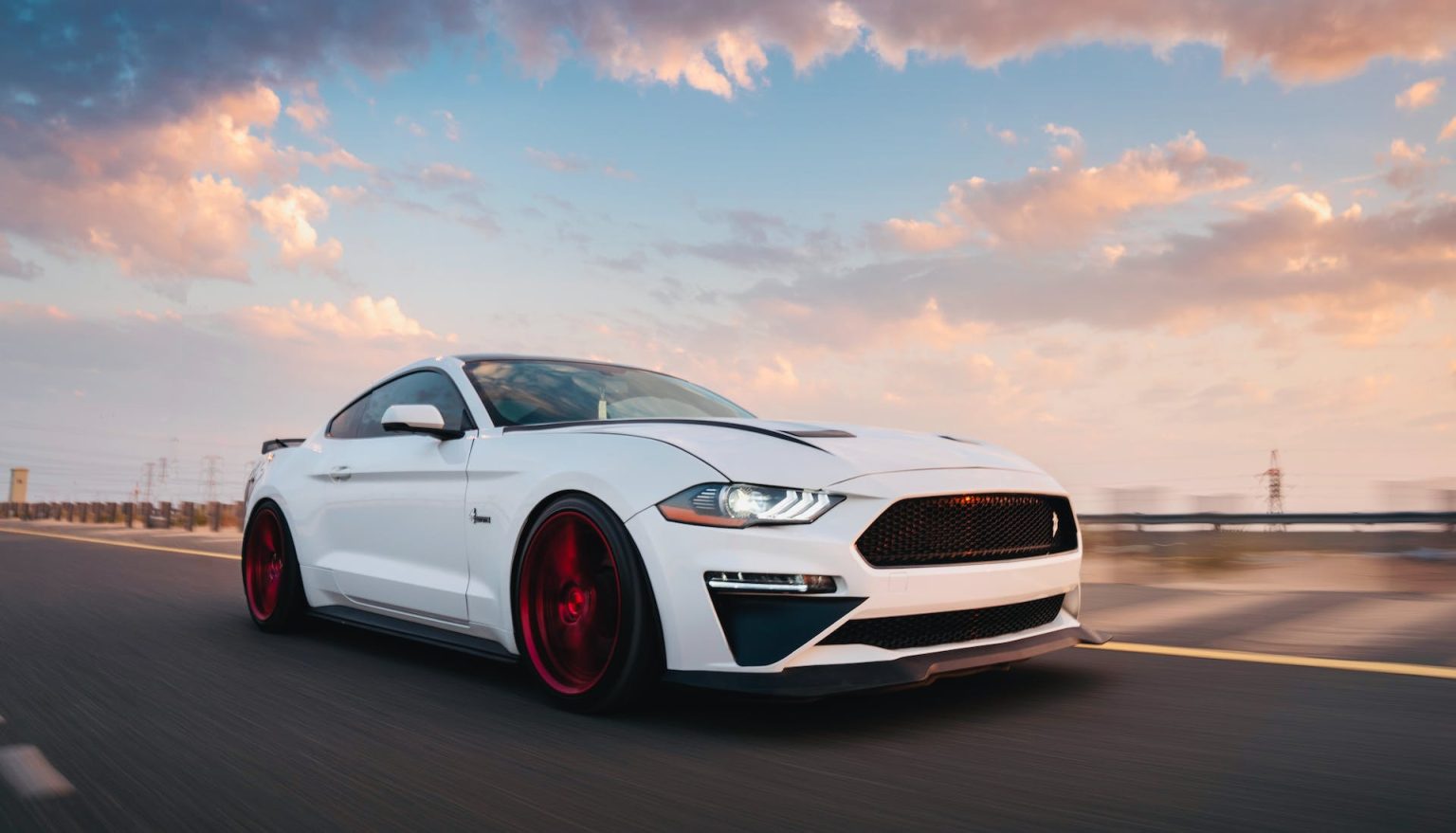 white ford mustang with red wheels