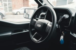 A close-up of a car's steering wheel, representing the act of lending your car to another driver.