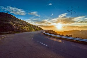 A long, open highway at sunrise, symbolizing the beginning of a Memorial Day road trip.