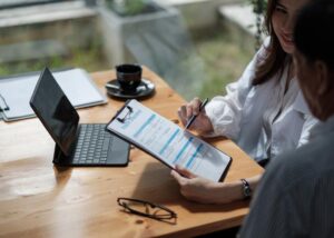 Two insurance agents or adjusters looking at a clipboard, symbolizing the evaluation of a policy or claim after a natural disaster.